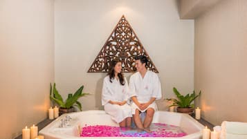 Relax in a serene space with a bathtub, decorative wall piece, and potted plants.