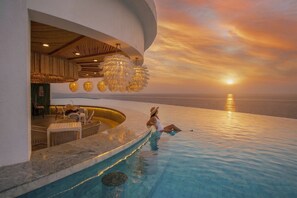 A poolside area with a sunset view, a bar, and outdoor seating. -  Royal Cliff Beach Hotel Pattaya (Pattaya)