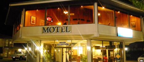 Un motel con una zona de recepción, un letrero que indica Anchor Room y una entrada visible.