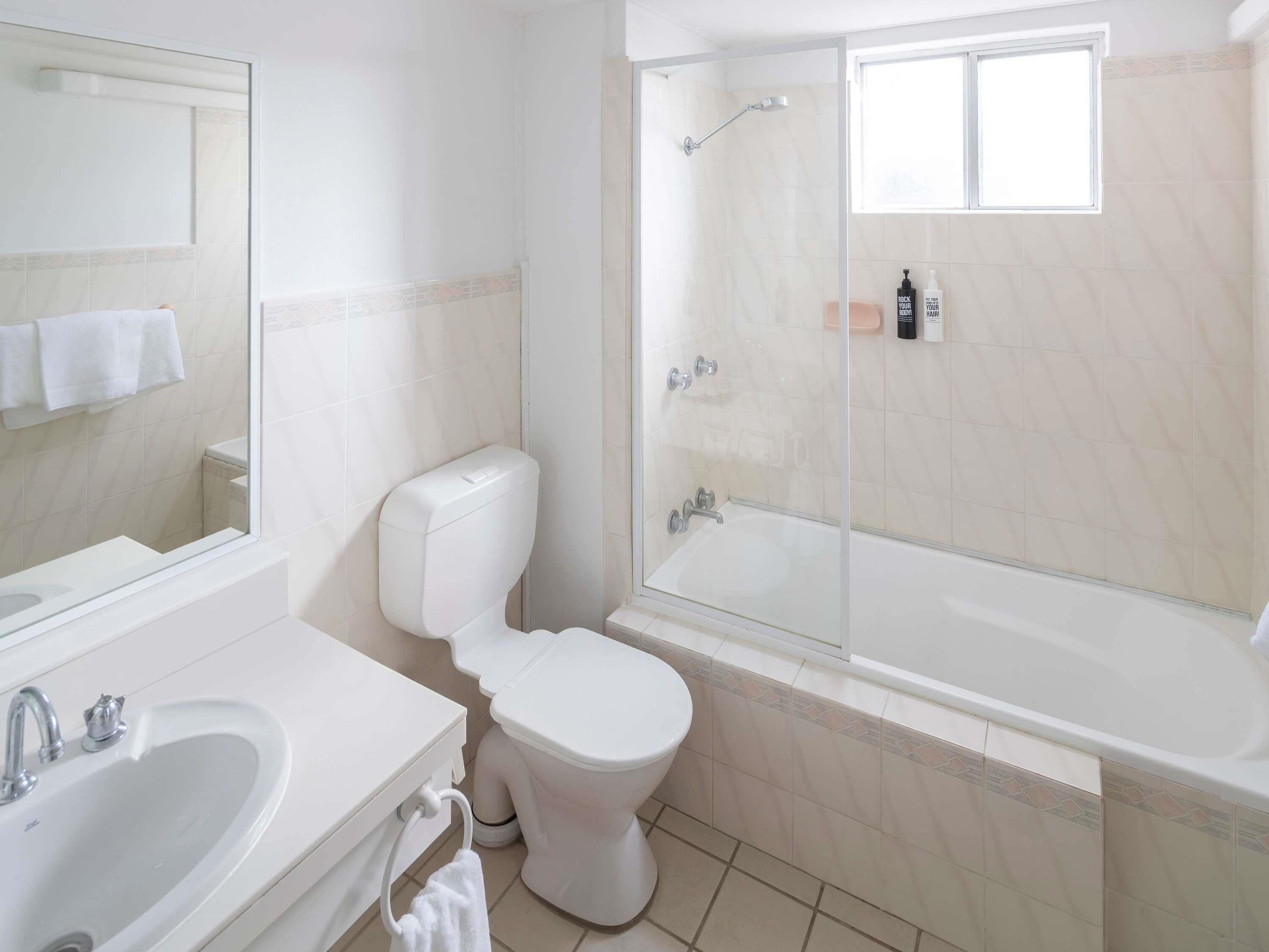 Ein modernes Badezimmer mit Toilette, Waschbecken und einer Duschkabine.