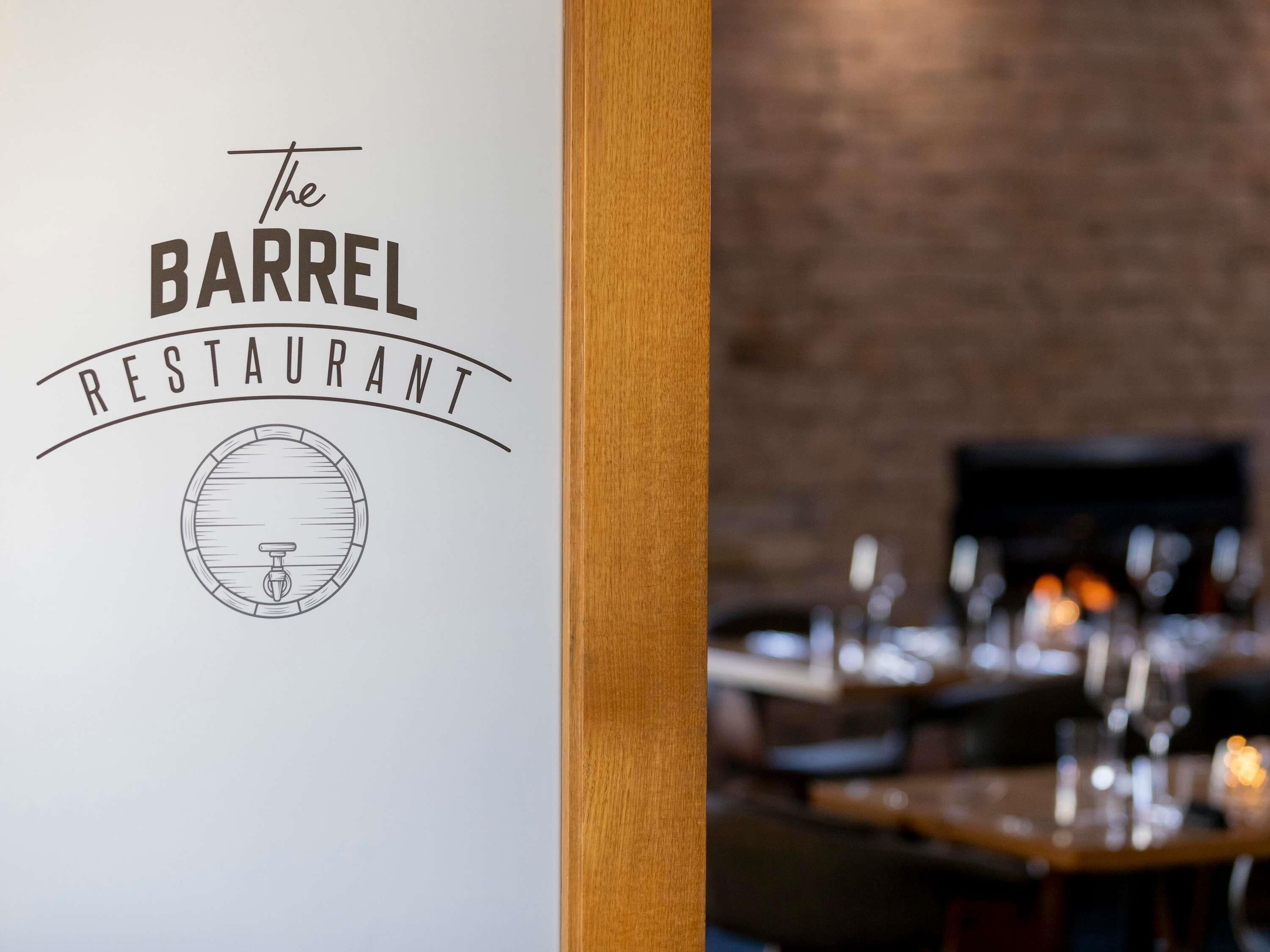 Uma placa de restaurante com um logotipo de barril e um emblema circular.