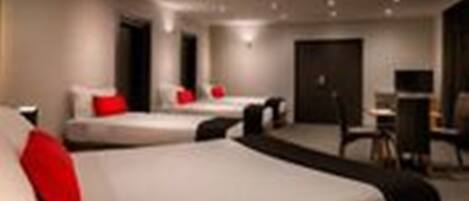 A modern hotel room with two beds, a desk, and a chair.
