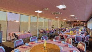 Un grand espace dédié à la salle à manger, avec des tables rondes, des chaises et un comptoir de bar.