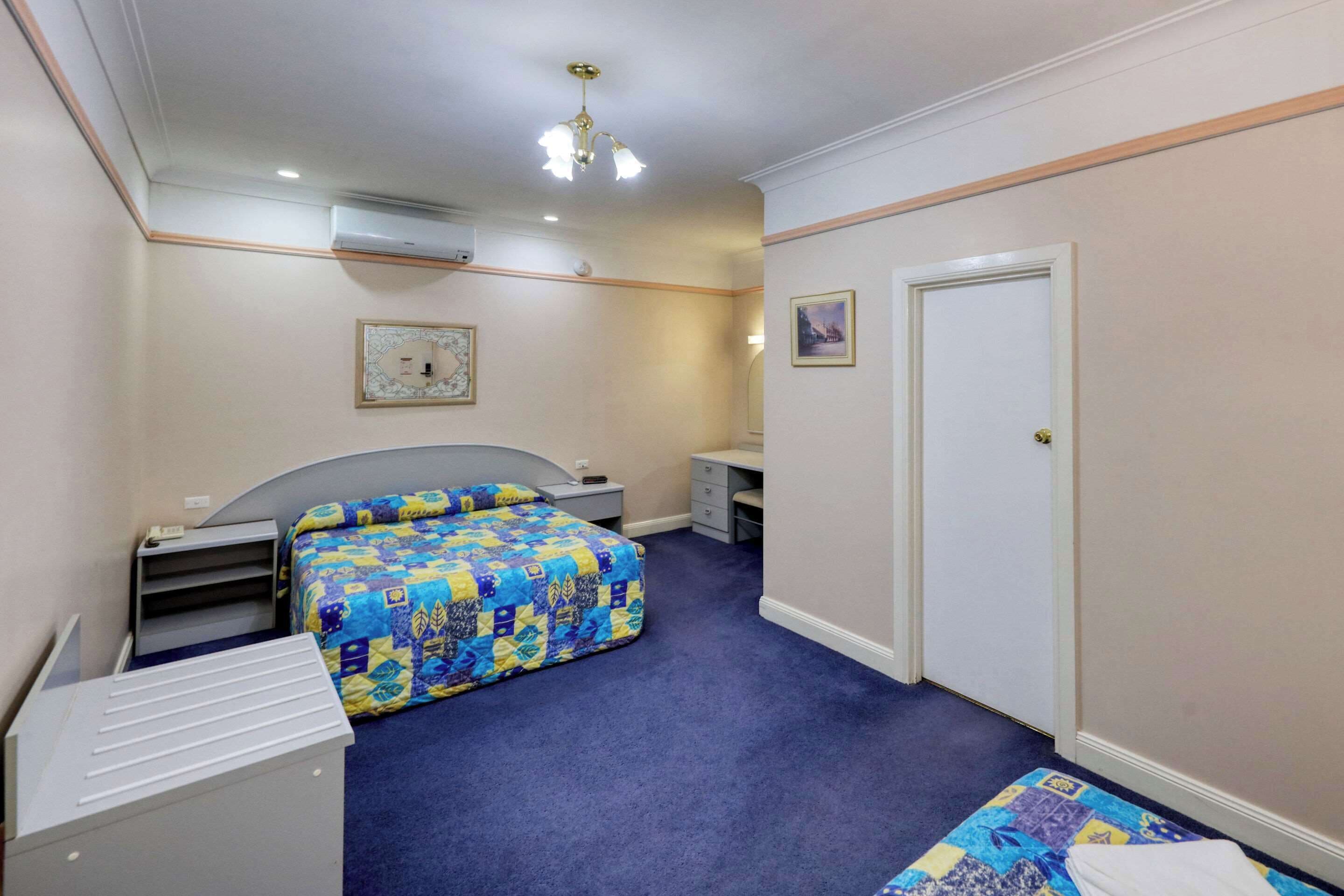 Un dormitorio con cama, escritorio, silla y armario.