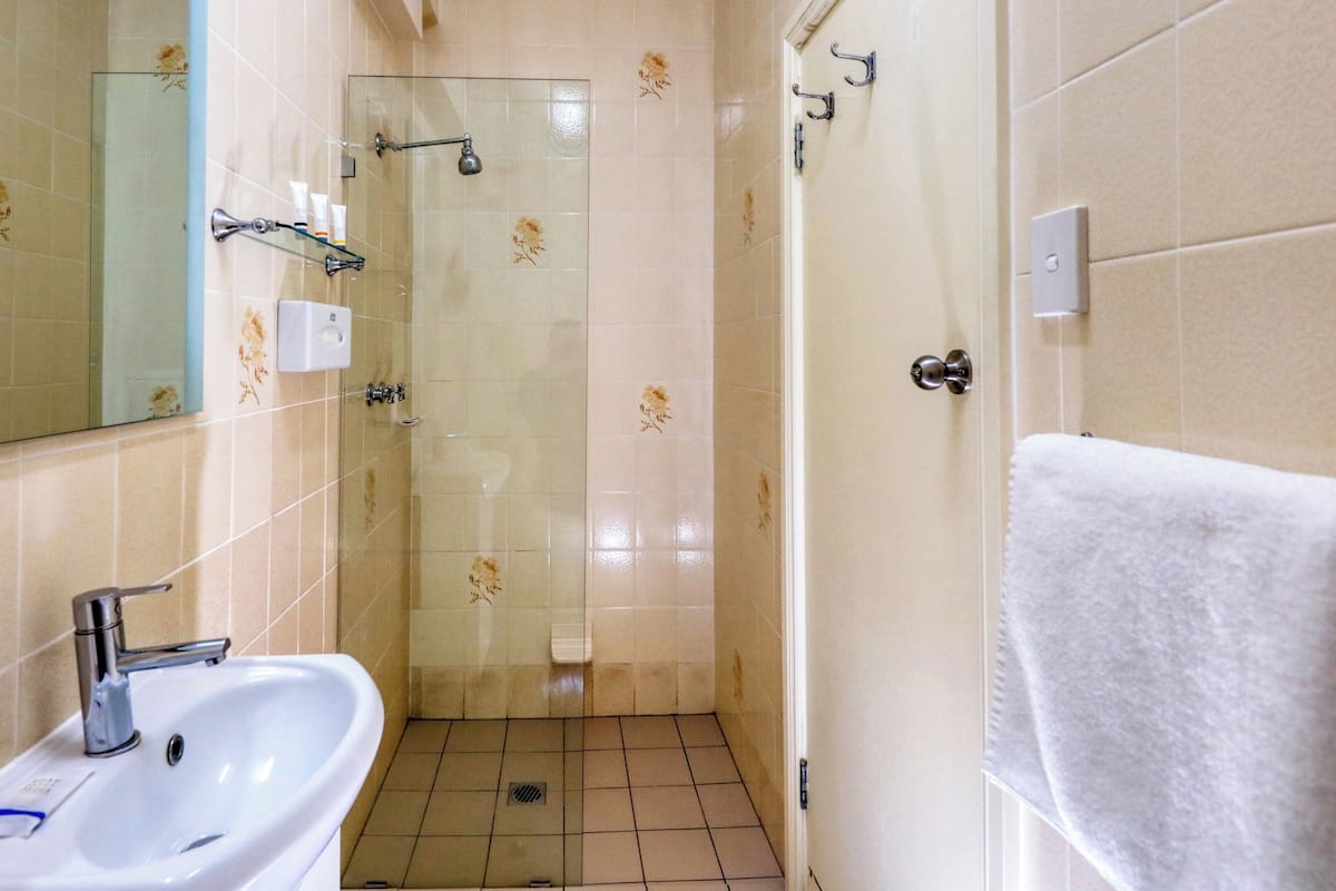 deluxe suite | bathroom | shower, rainfall showerhead, hair dryer, towels