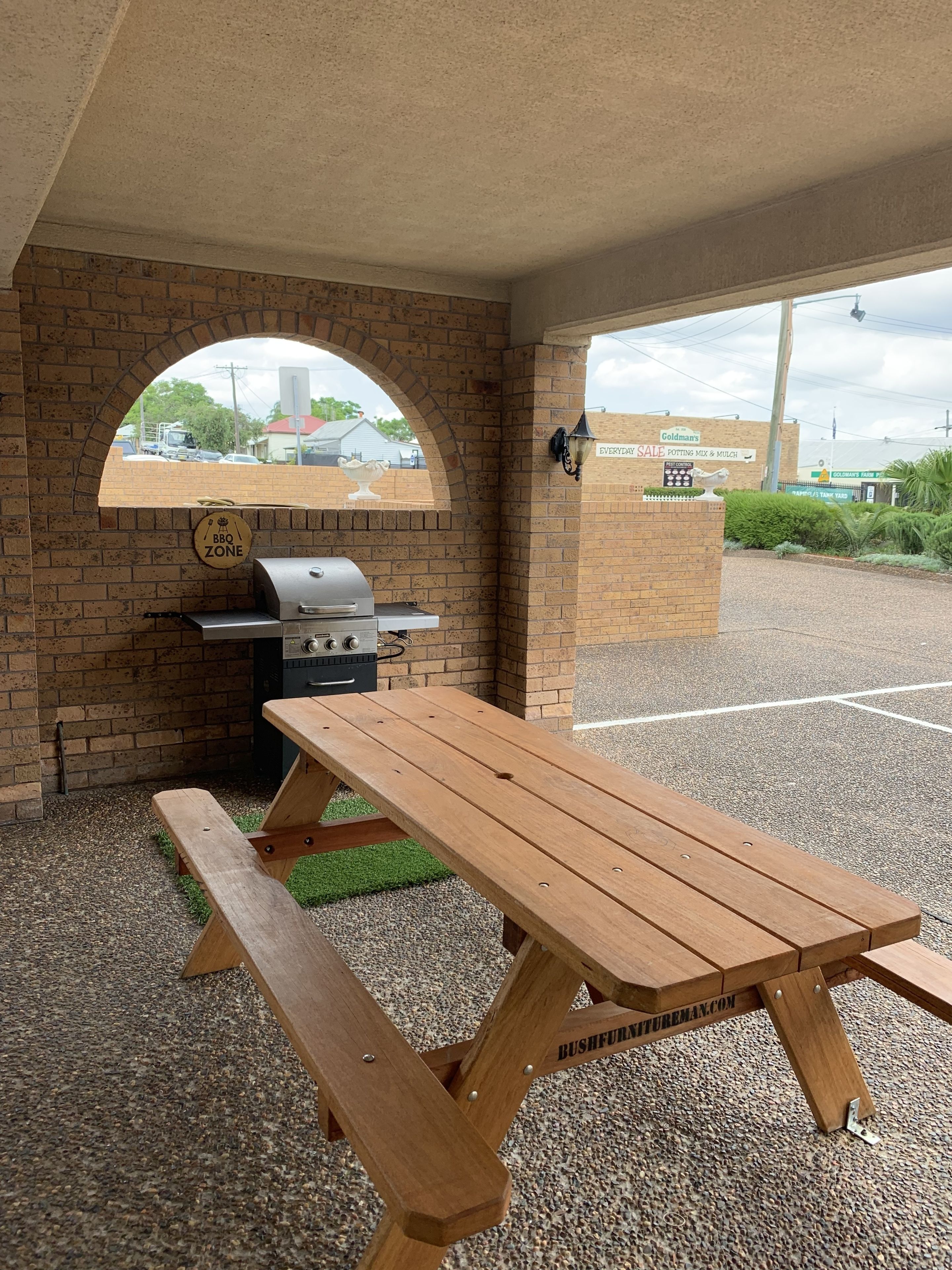 A BBQ zone with a grill and a picnic table.