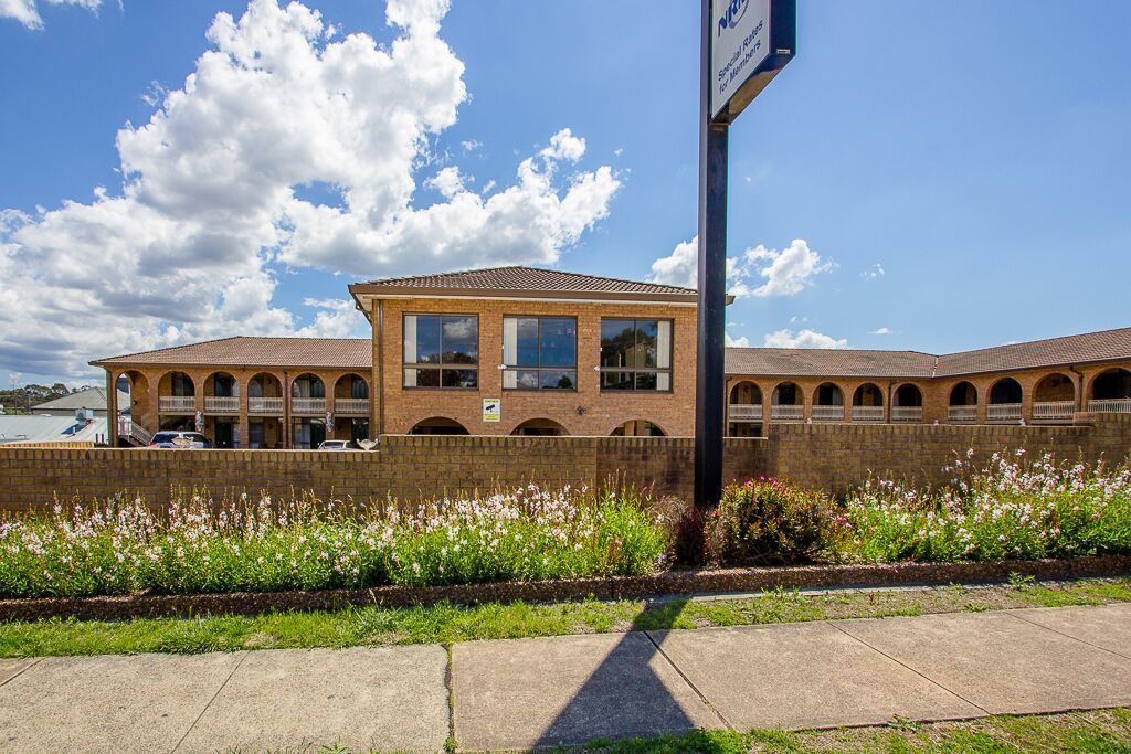 A building with a brick facade, multiple windows, and a flat roof.