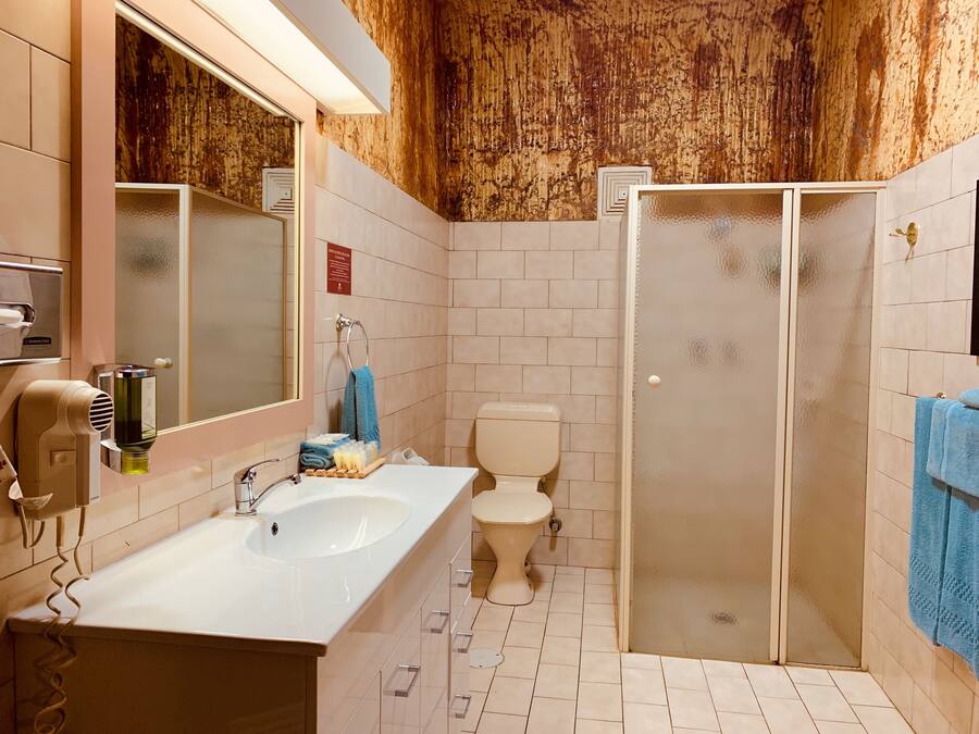 A bathroom with a white sink, a toilet, and a glass-enclosed shower.