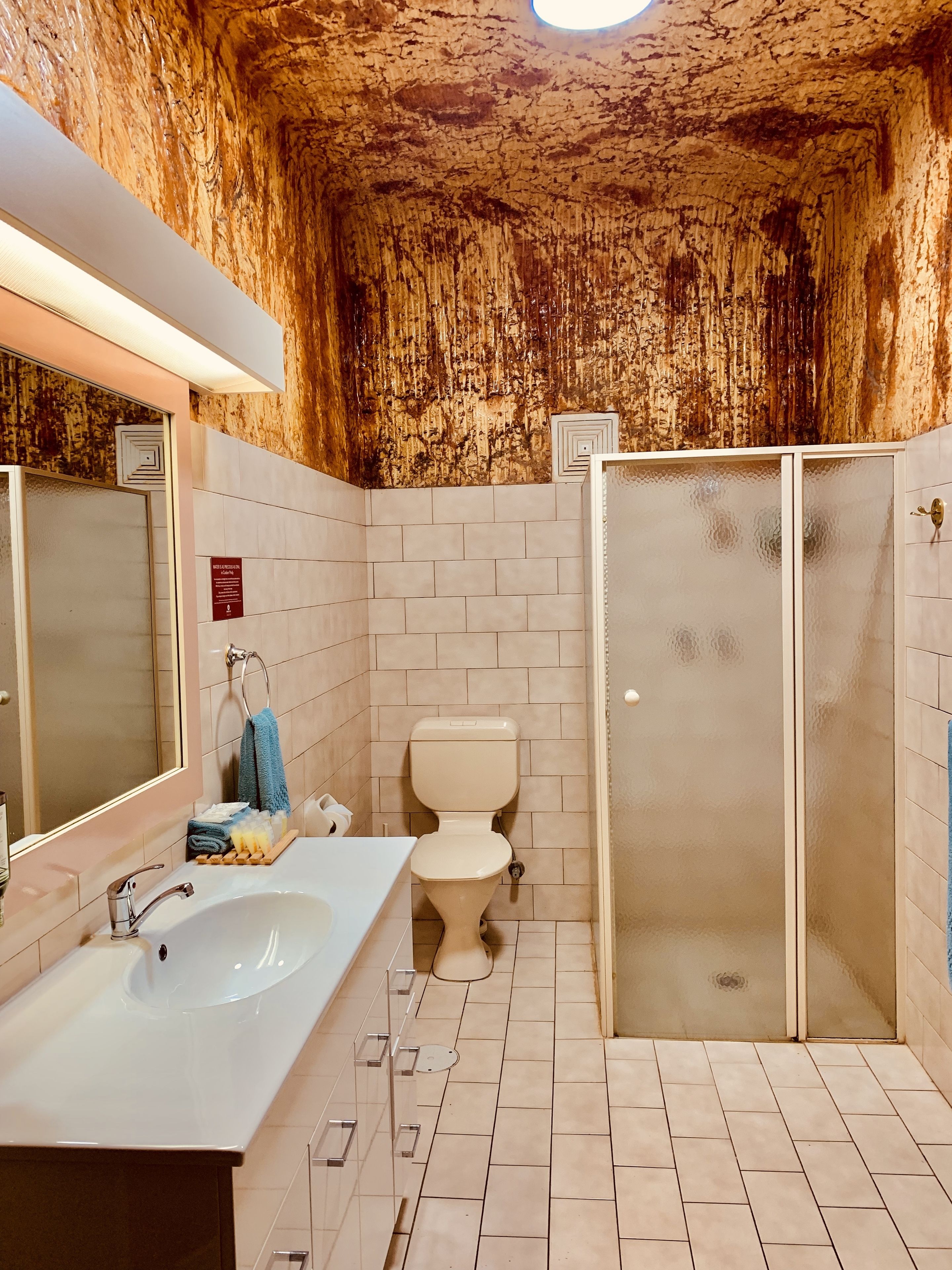 Un bagno con lavandino, WC e cabina doccia in vetro.
