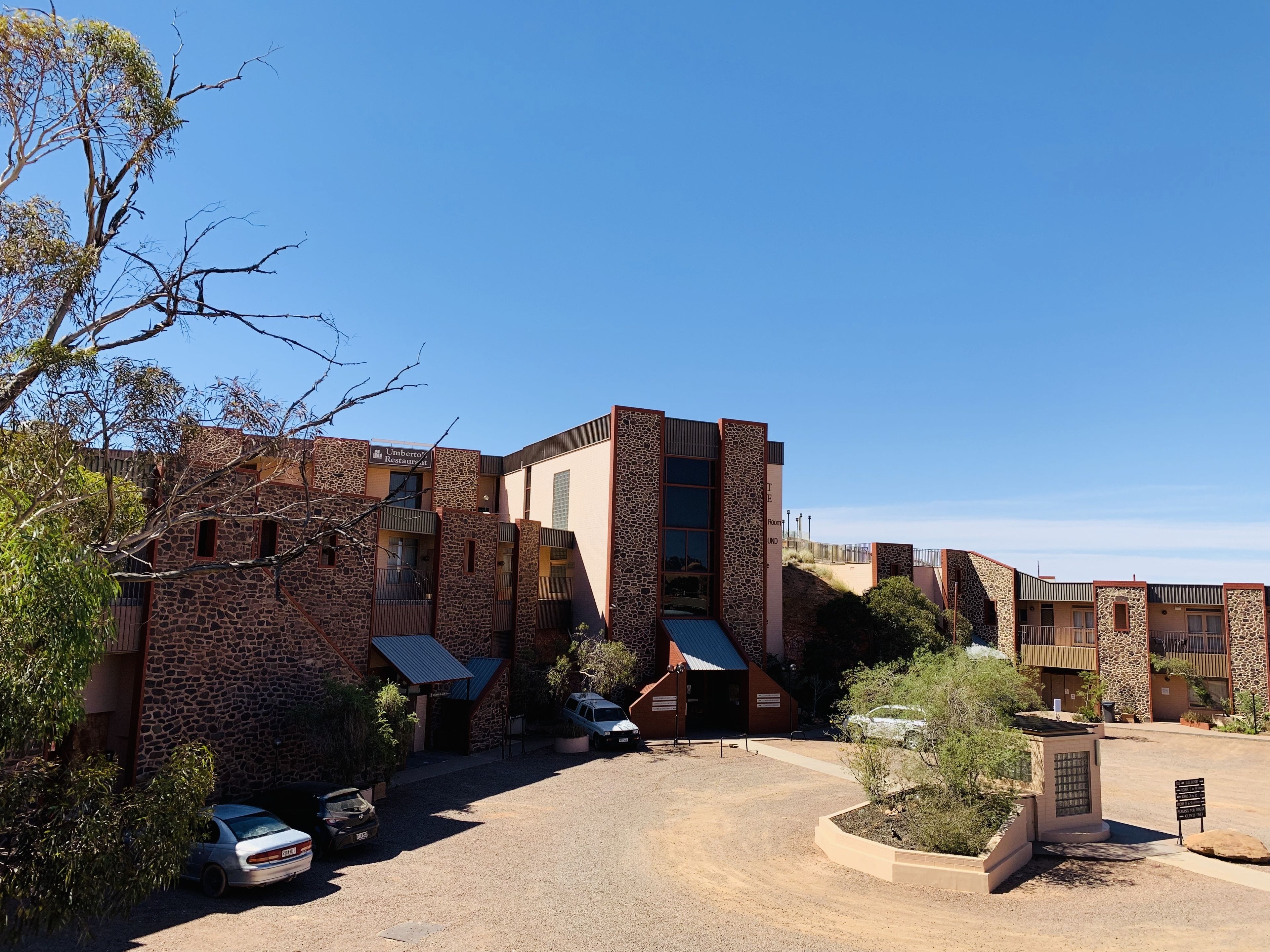 Un edificio moderno con fachada de piedra y varios balcones.