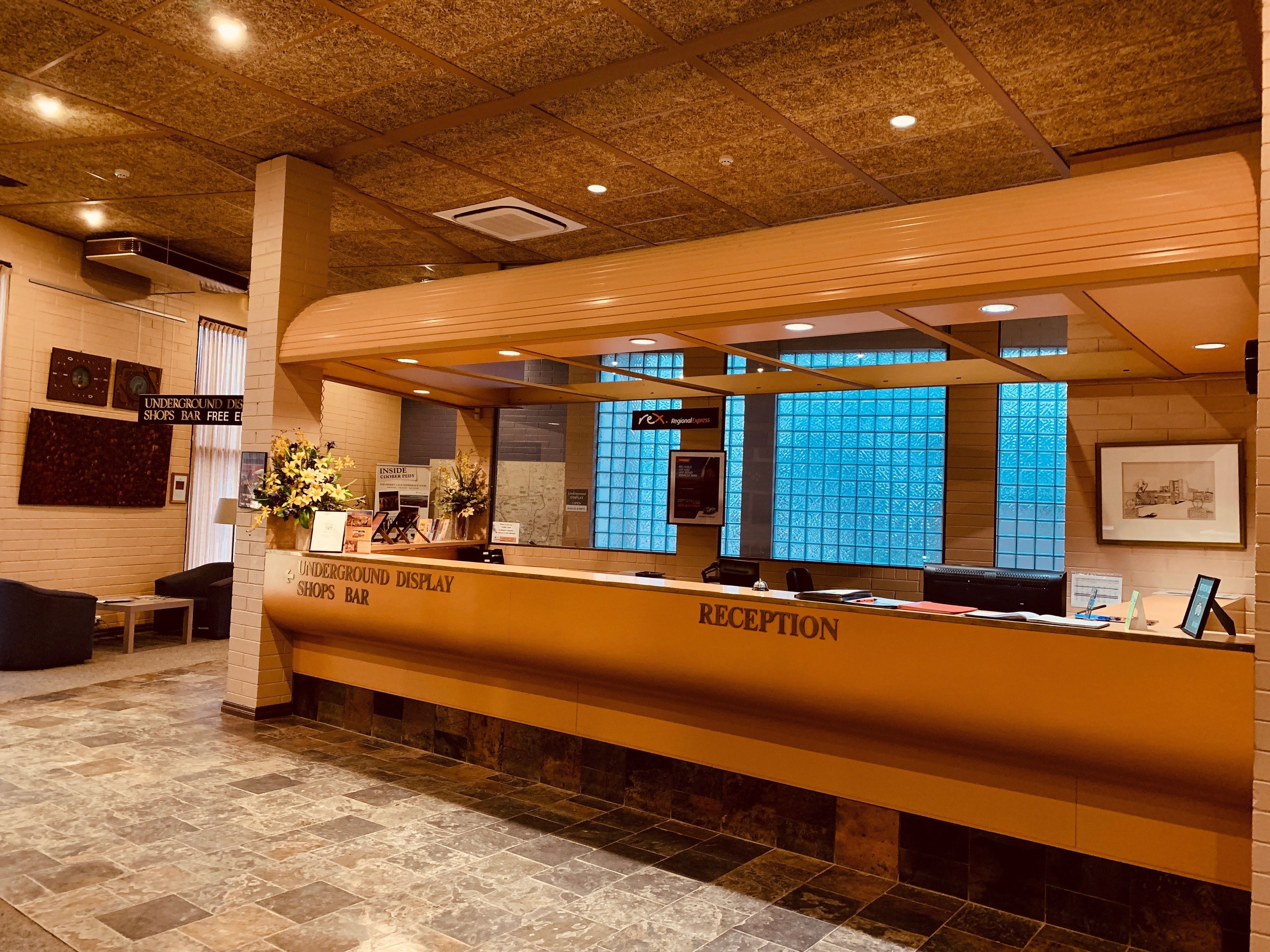A reception area with a reception desk, a seating area with chairs, and a wall-mounted display.