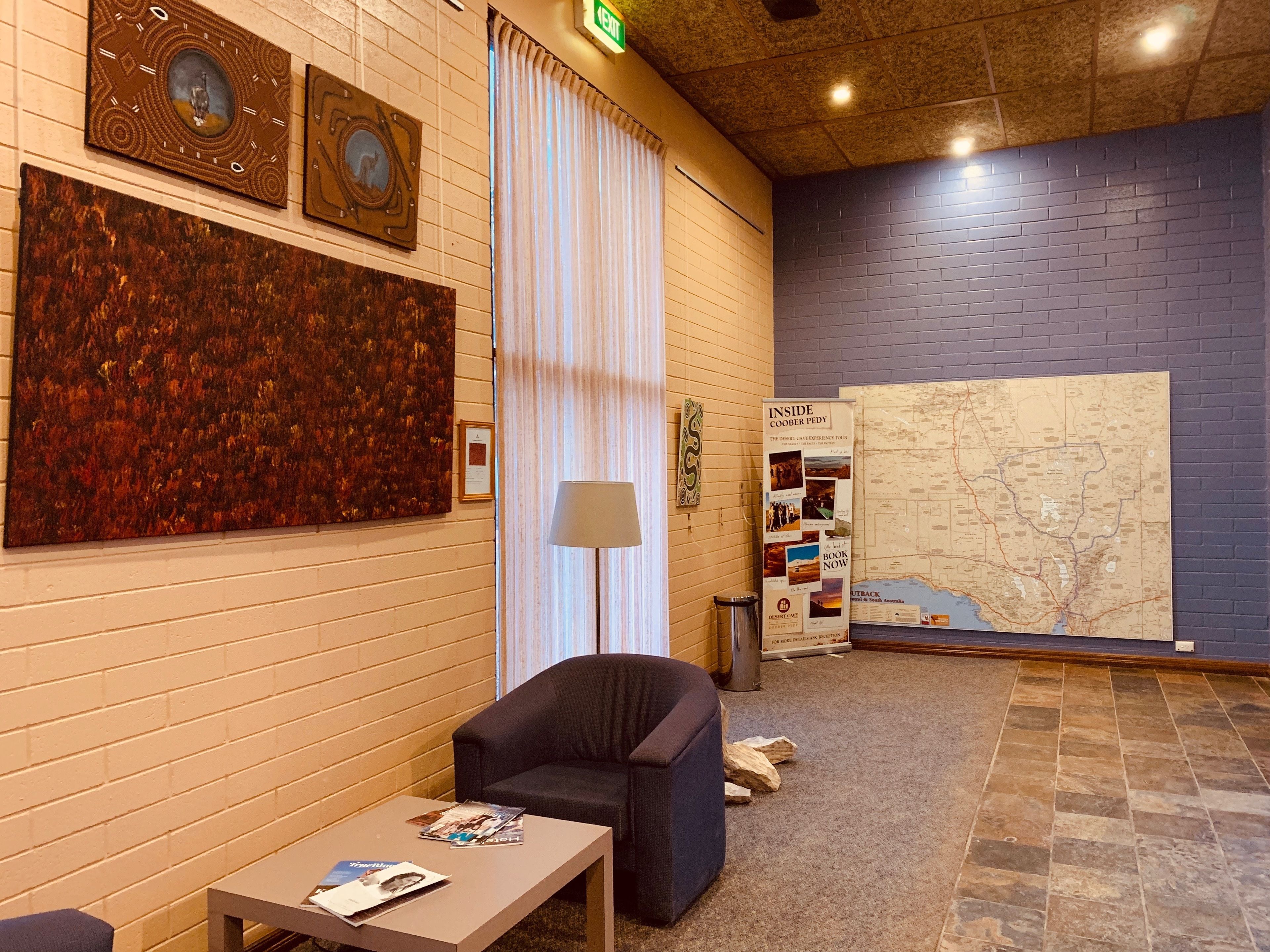 A lobby with a large map, framed artwork, and a seating area.