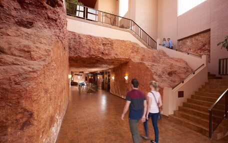 A spacious lobby with a high ceiling and a large rock-like feature.