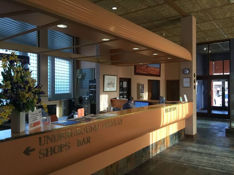 A reception desk with a sign indicating an underground shops bar.