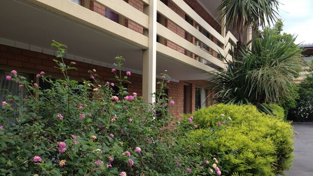 A multi-story building with a brick facade and balconies.