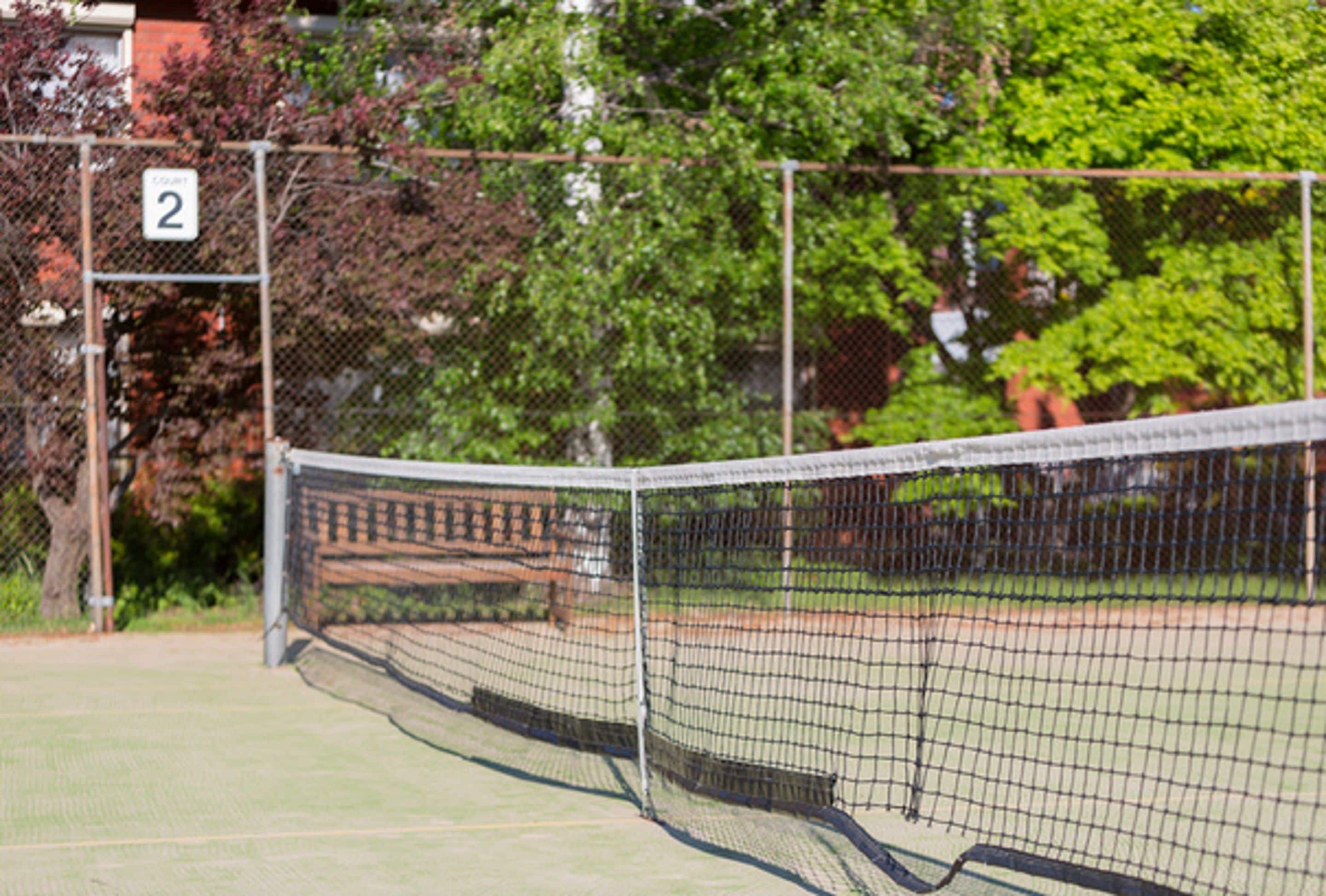 Pista de tennis amb xarxa, tanca i senyalització del número 2.