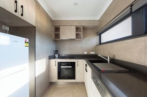Una cocina compacta equipada con lavavajillas, estufa y microondas.