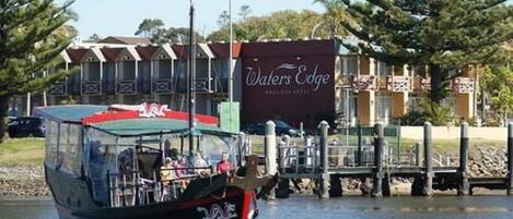 A boat with 'Waters Edge' signage docked at a marina.