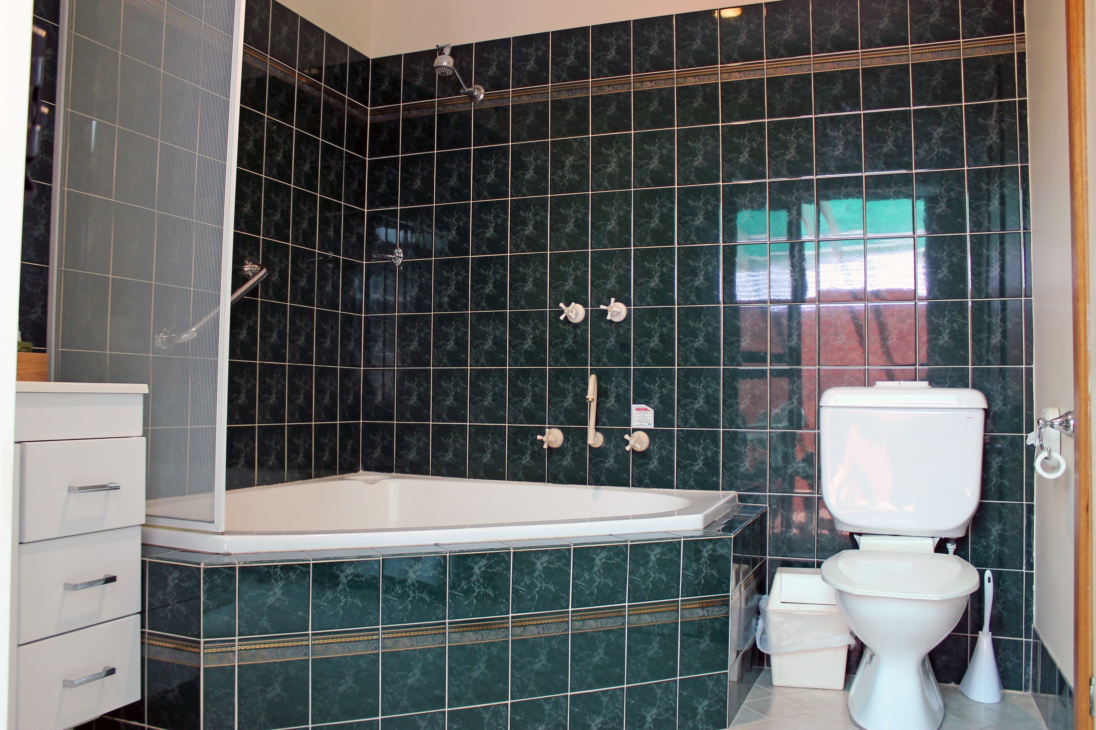 A bathroom with a bathtub, toilet, and shower.