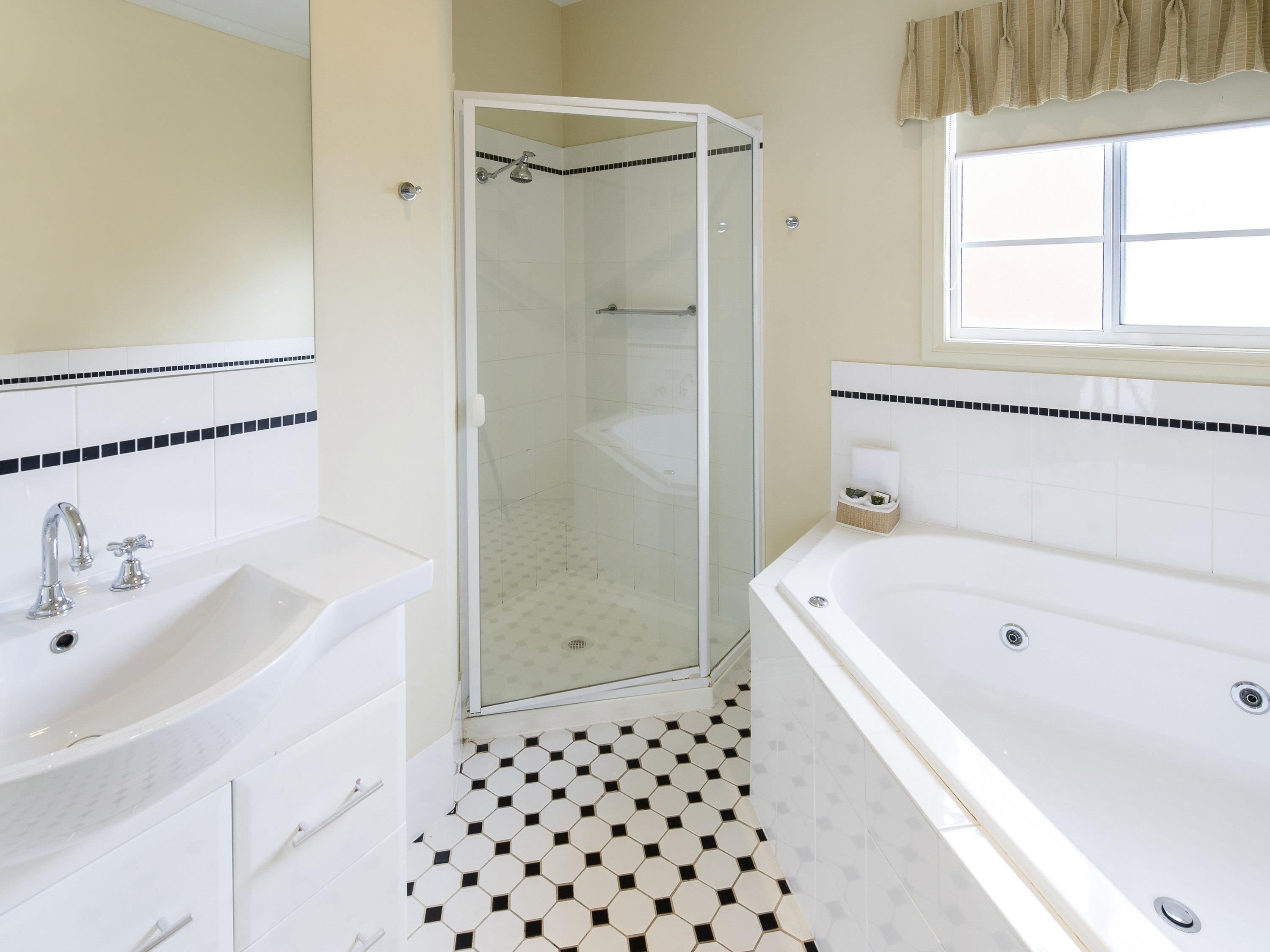A bathroom with a shower, a bathtub, and a sink.