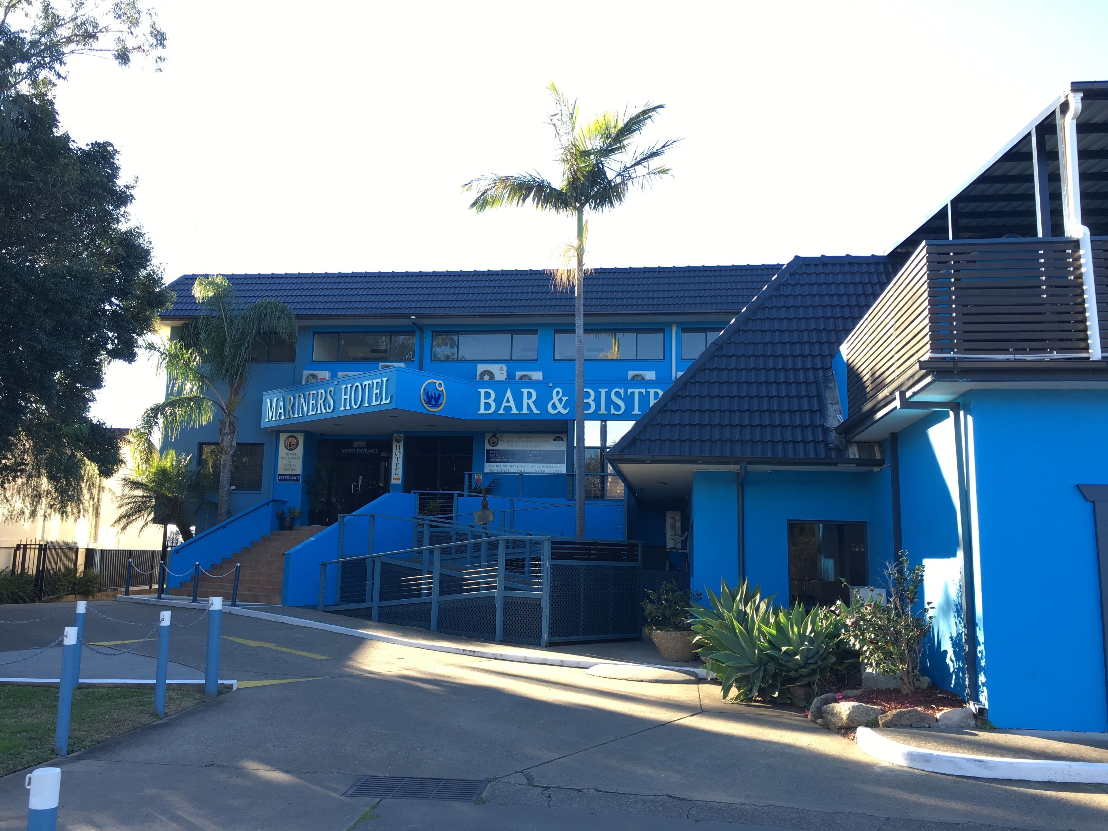 Un edificio azul con un letrero que dice "MARNERS HOTEL BAR & BISTRO".