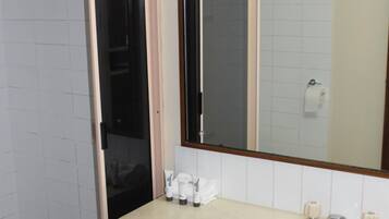 A bathroom with a sink, mirror, and shower.