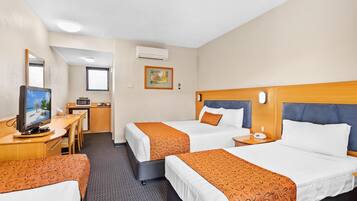 A hotel room with two beds, a desk, a television, and a microwave.