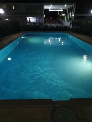 Una piscina al aire libre, tumbonas