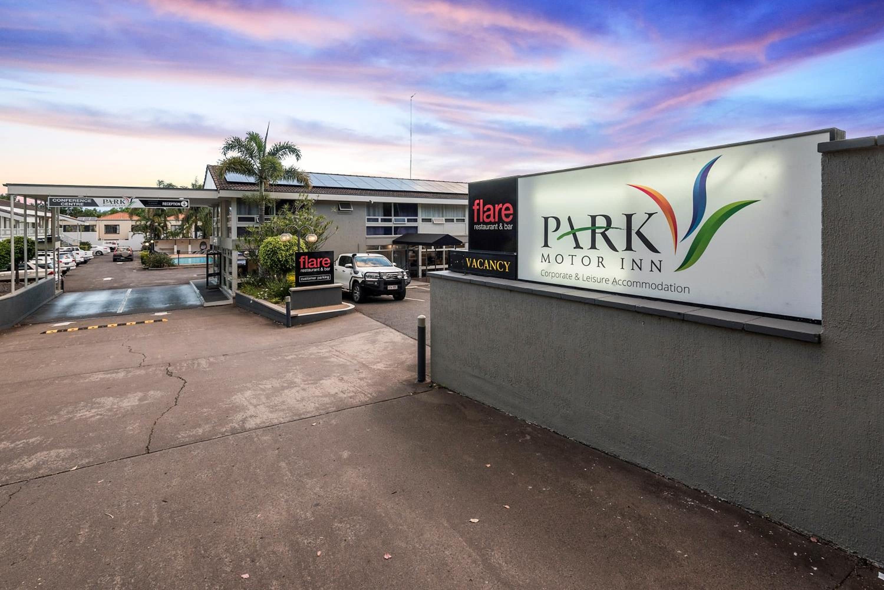 A parking area with a sign for 'flare restaurant & bar' and 'PARK MOTOR INN' indicating corporate and leisure accommodation.