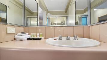 Un bagno con uno specchio grande, un lavandino e articoli da toilette.