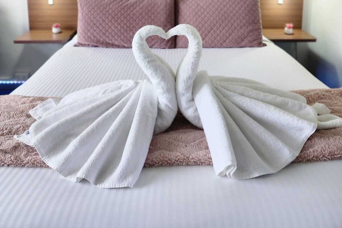 A hotel room with a bed, two nightstands, and wall art.
