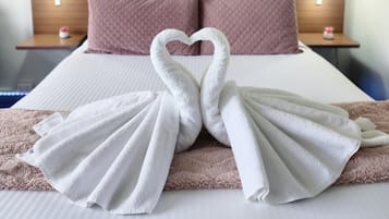 Una habitación de hotel con una cama, dos mesitas de noche y decoración en la pared.
