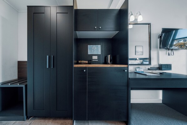 Habitación triple Deluxe | Área de sala de estar | Televisión de pantalla plana de 40 pulgadas con canales por cable 