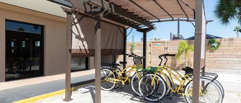 A covered outdoor area with bicycles parked under a pergola.