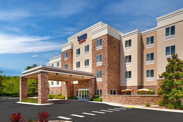 Un hotel con fachada de piedra, un acceso cubierto y un letrero que indica que es un Fairfield Inn & Suites.