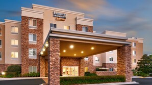 Un hotel Fairfield Inn & Suites Marriott con fachada de ladrillo, entrada cubierta y un estacionamiento bien iluminado.