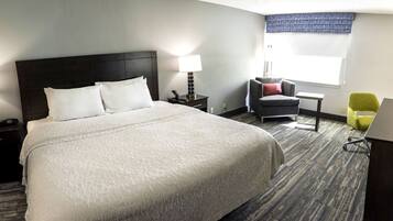 Escritorio, cortinas blackout y tabla de planchar con plancha