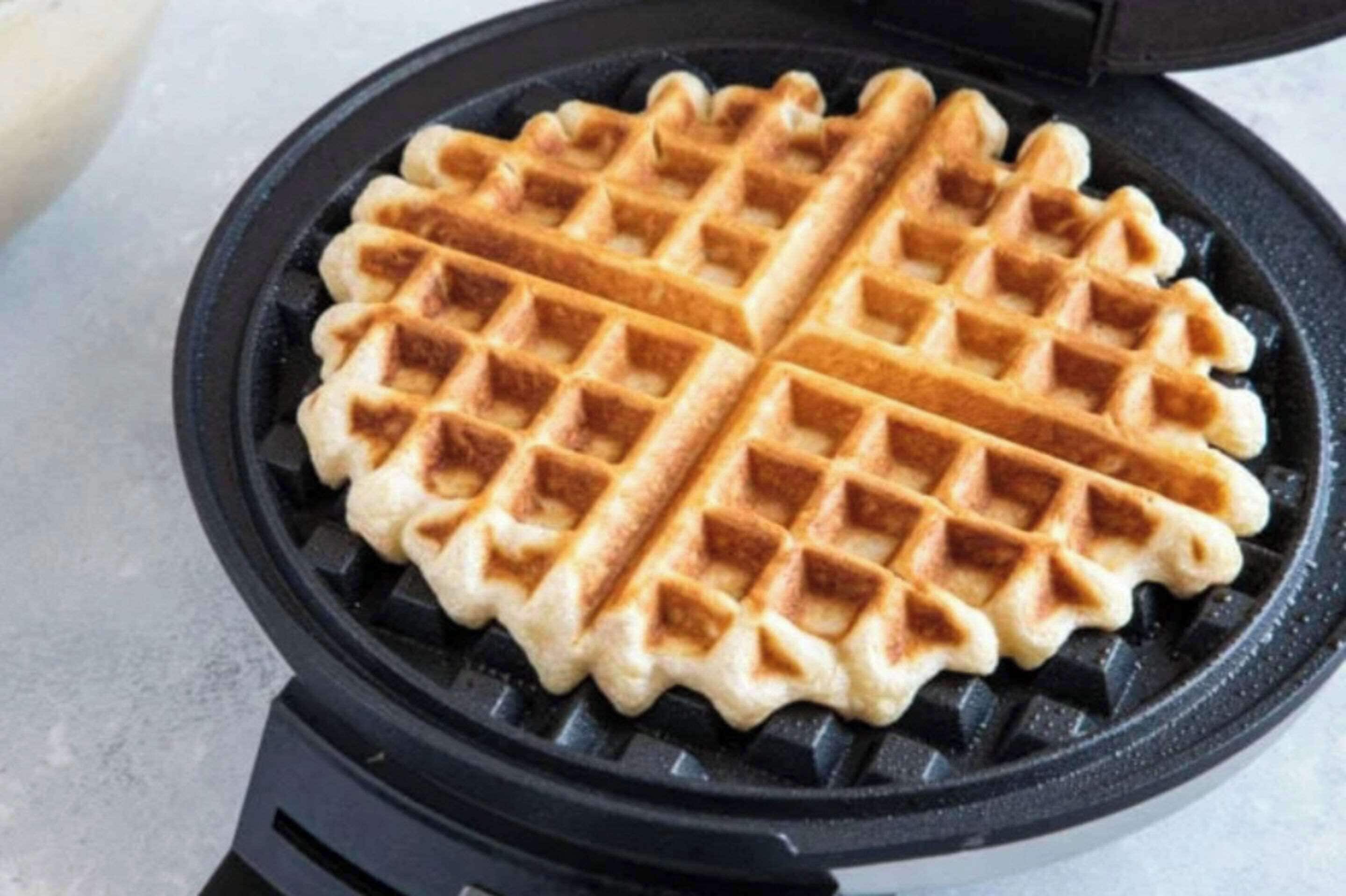 Una plancha para gofres con un gofre dentro.
