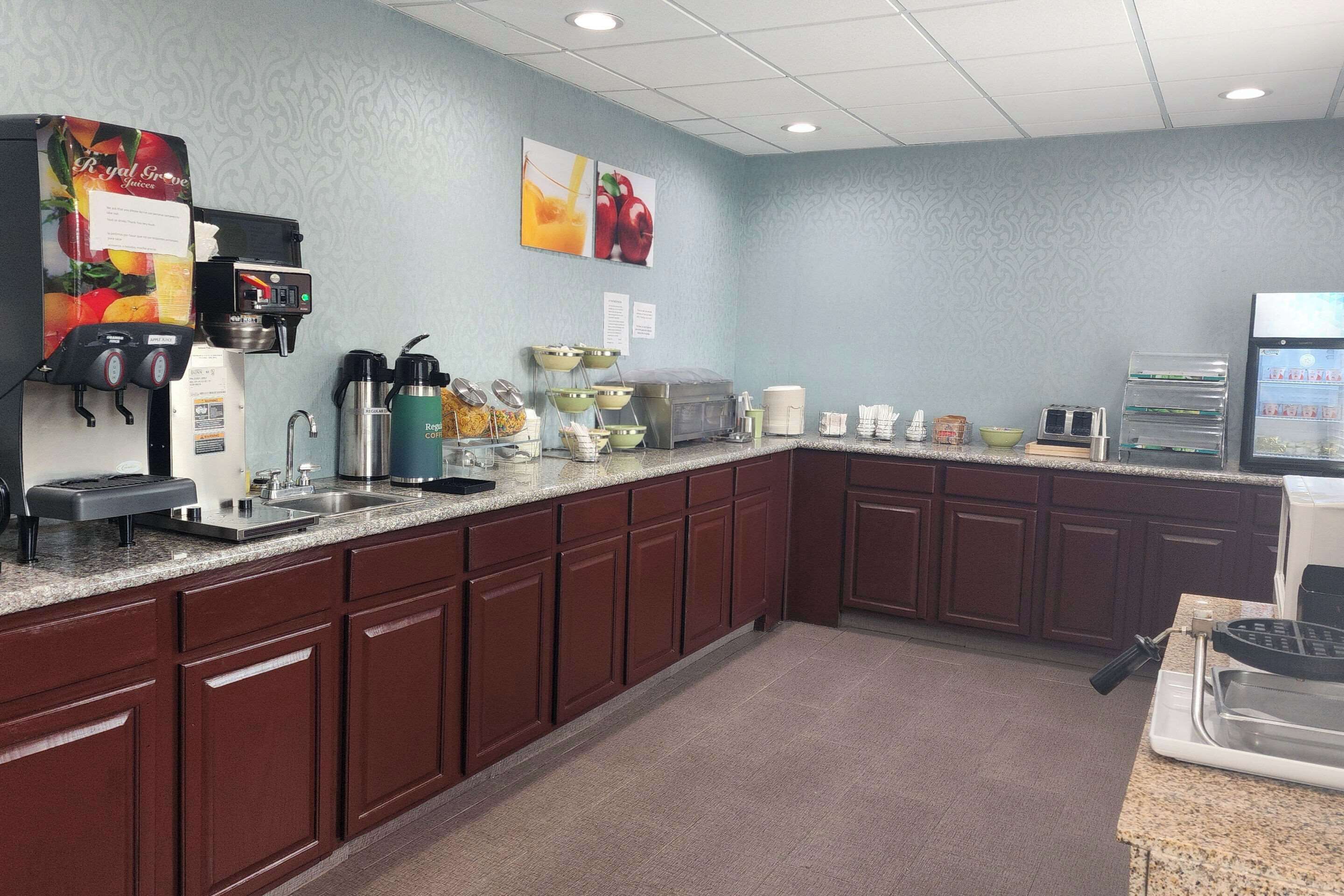 A kitchen area with a coffee machine, a microwave, and a toaster. There are cabinets and a countertop.