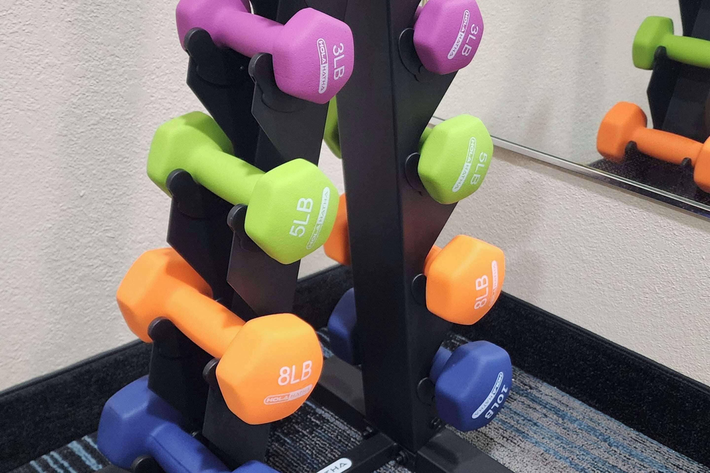 Telineessä on useita käsipainoja, joiden painot on merkitty: 3 paunaa, 5 paunaa ja 8 paunaa.