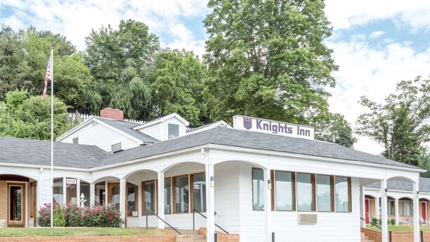 A Knights Inn with a white exterior, multiple windows, and a brick entrance. - Knights Inn Galax (Galax)