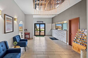 A spacious lobby with a reception desk, seating area, and a view of the outdoors. - Baymont by Wyndham Lebanon IN (Lebanon)