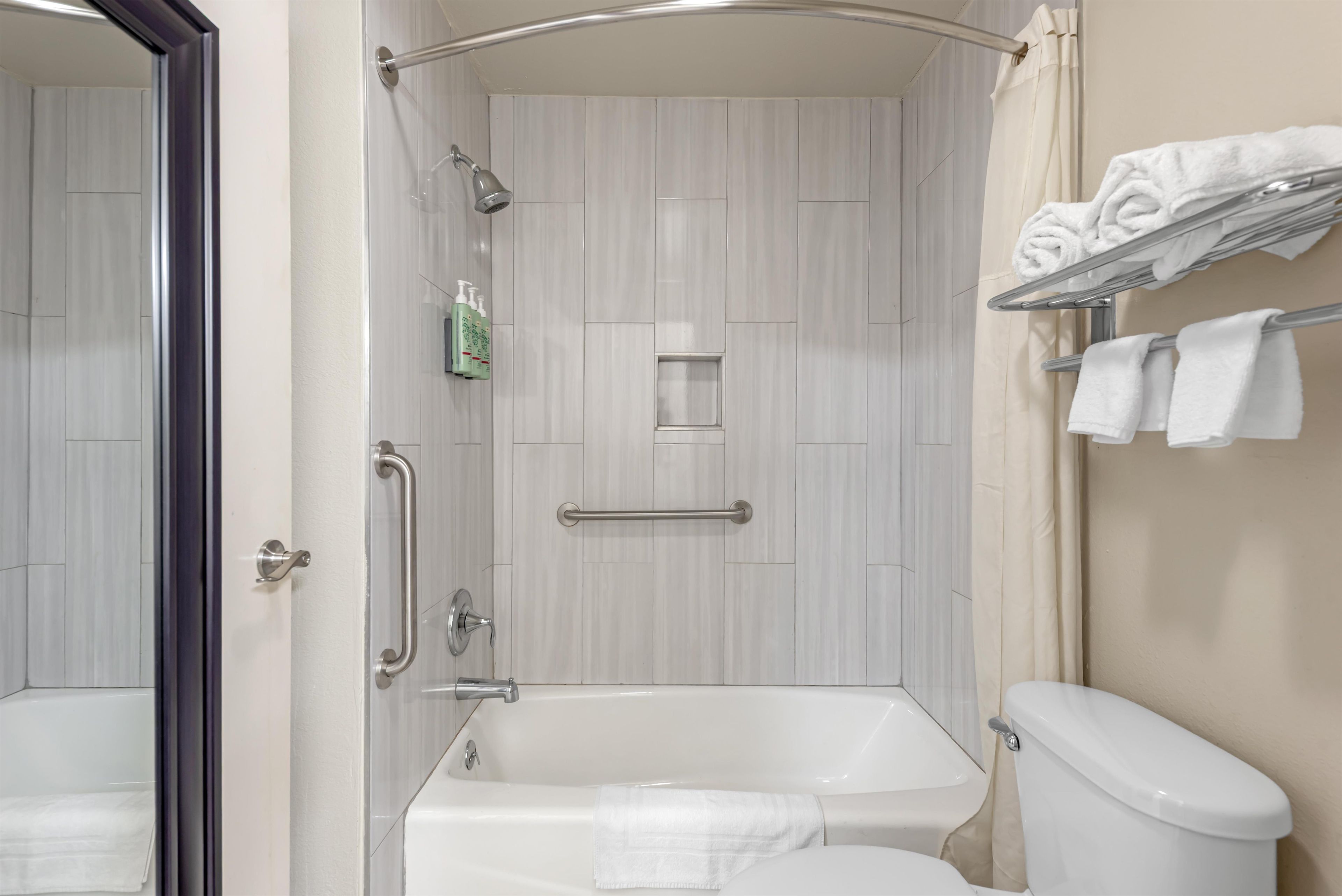 A bathroom with a bathtub, toilet, and a shower area.