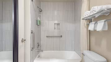 A bathroom with a bathtub, toilet, and a shower area.