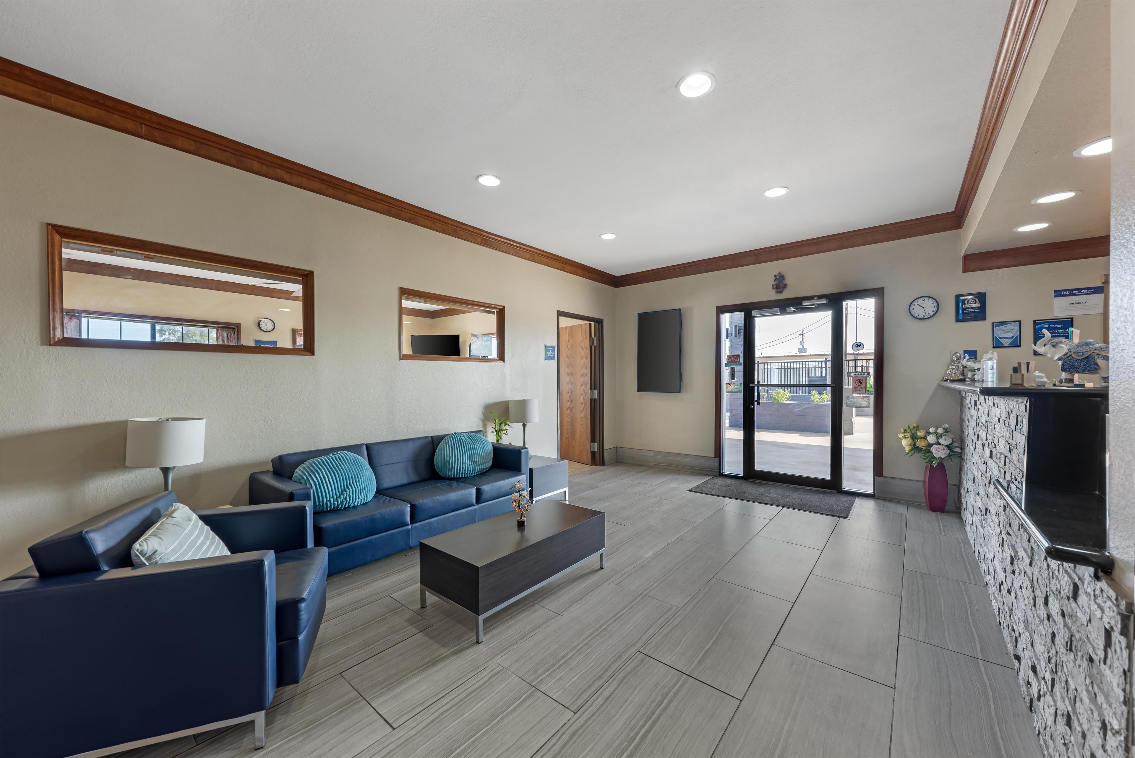 A hotel lobby with a blue sofa, a coffee table, and a reception desk.