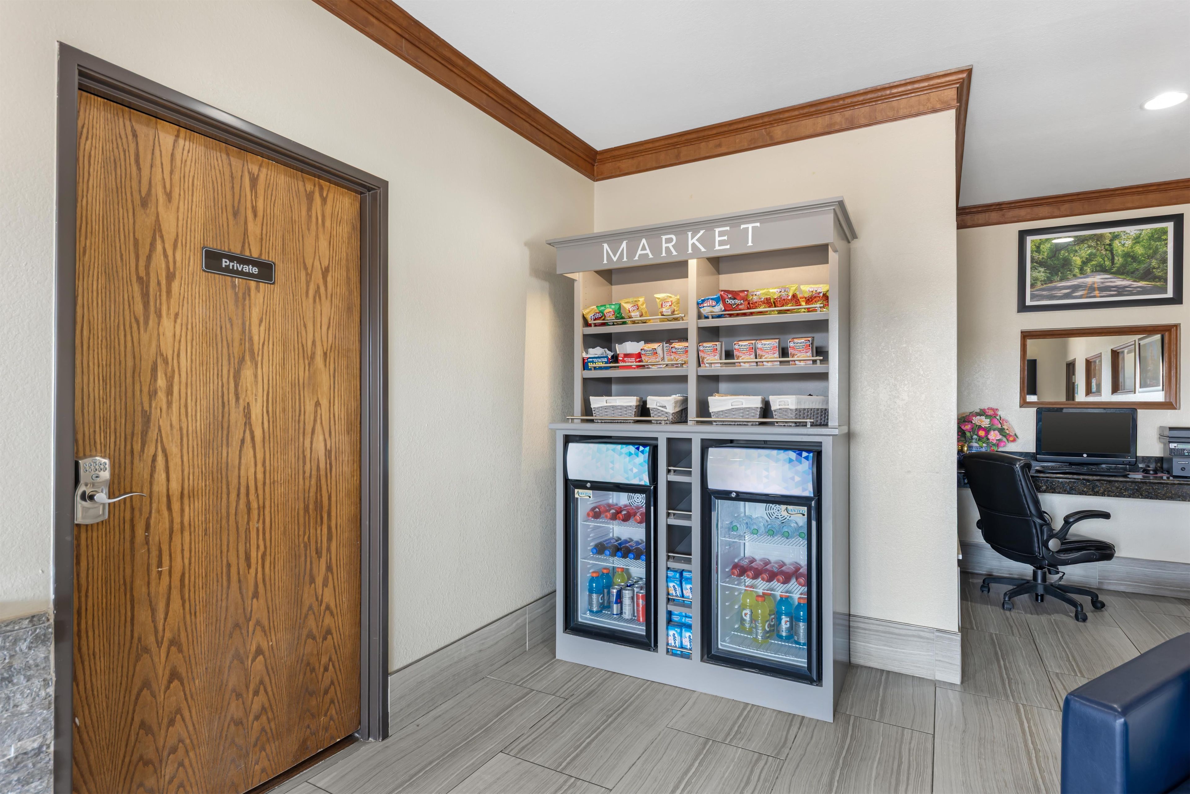 A private room with a wooden door, a kitchenette, a refrigerator with a 'Market' sign, and a computer desk.