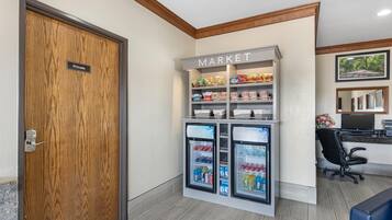 A private room with a wooden door, a kitchenette, a refrigerator with a 'Market' sign, and a computer desk.