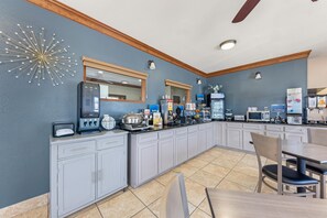 A modern kitchen with a built-in coffee station, microwave, and various food items. - Best Western Regency Inn & Suites (Gonzales)