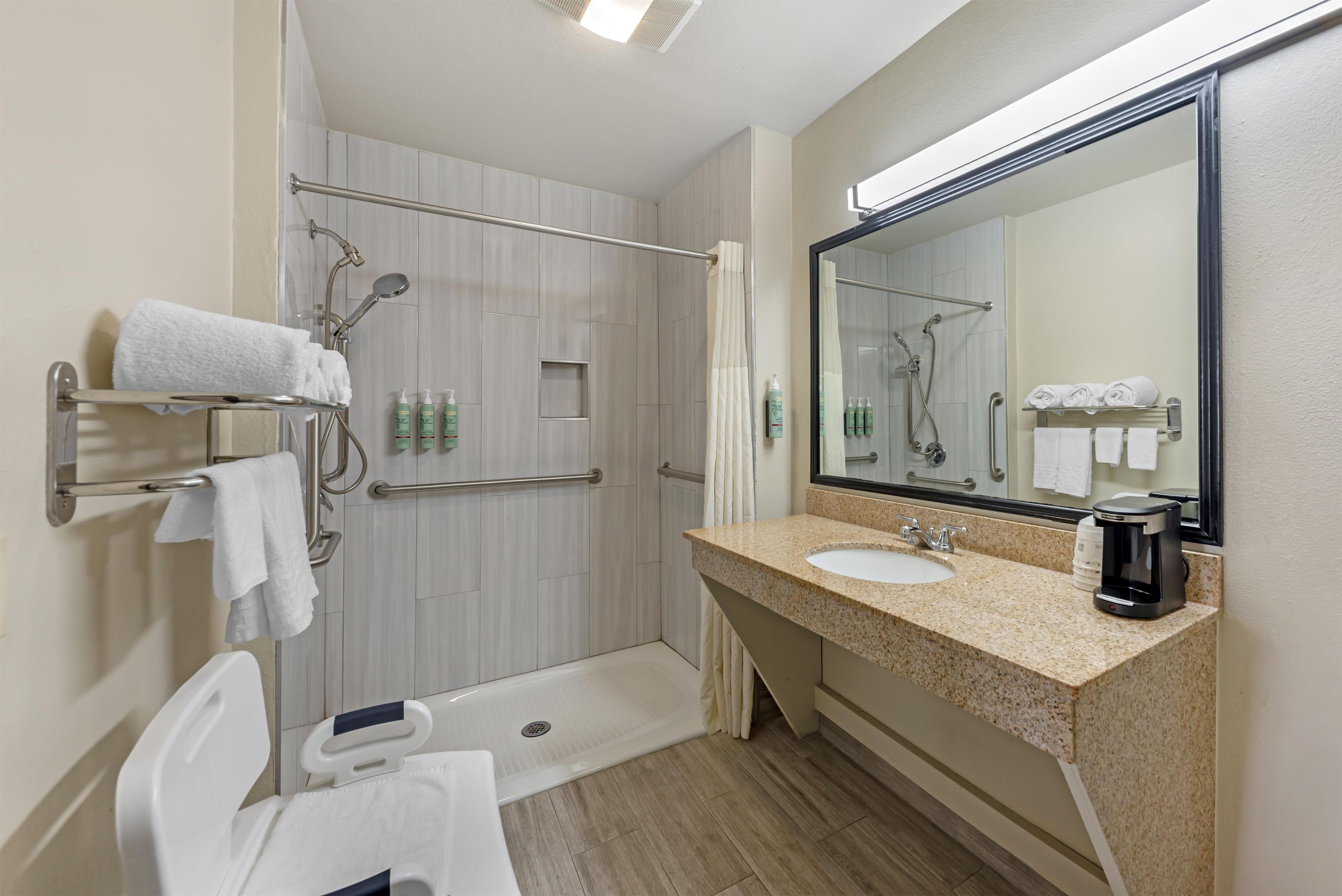 A modern bathroom with a shower, toilet, and sink.