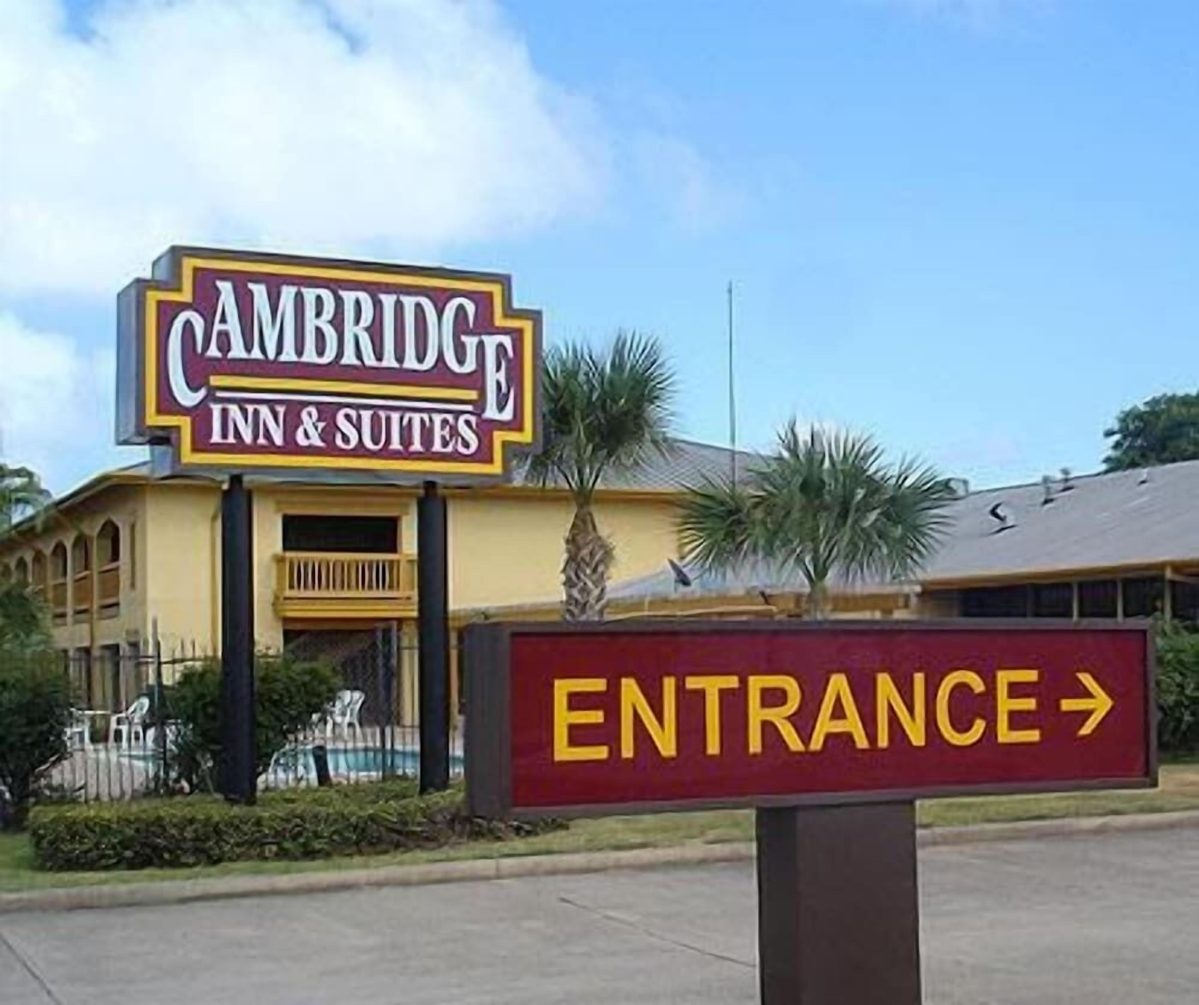 A hotel sign for Cambridge Inn & Suites with an entrance sign.